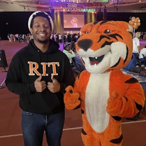 Student smiling with Ritchie the Tiger