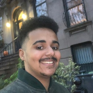 Student smiling in front of brick facade