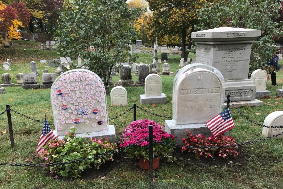 Susan B. Anthony’s grave at Mt. Hope Cemetery, marked with voting stickers, flowers, and American flags following Election Day.
