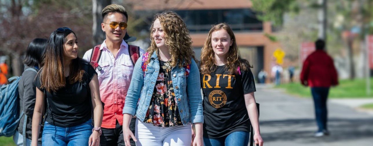 1+ MBA campus shot, 4 students walking