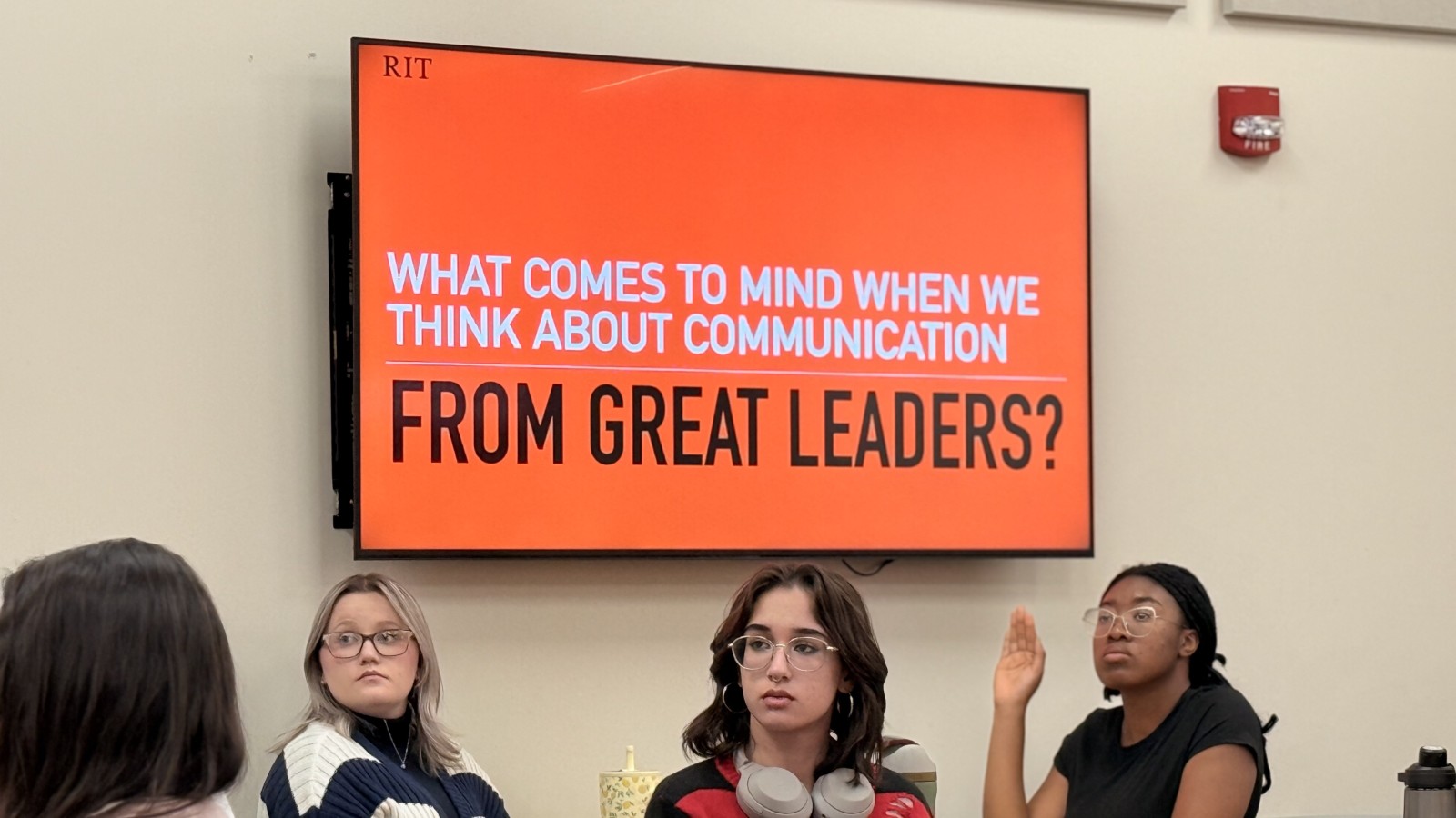 Students in lecture with a presentation behind