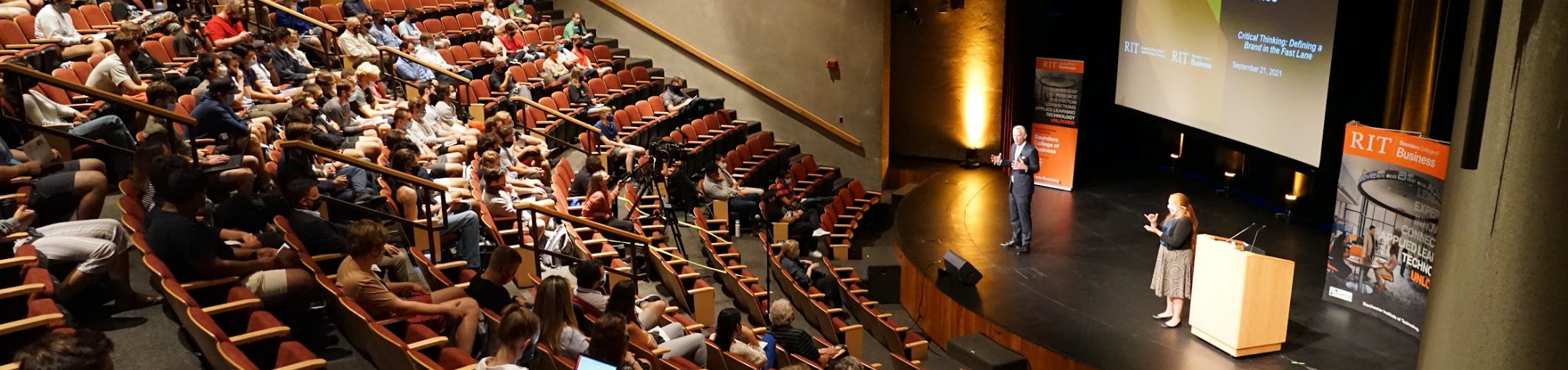 Speaker addressing a large lecture hall