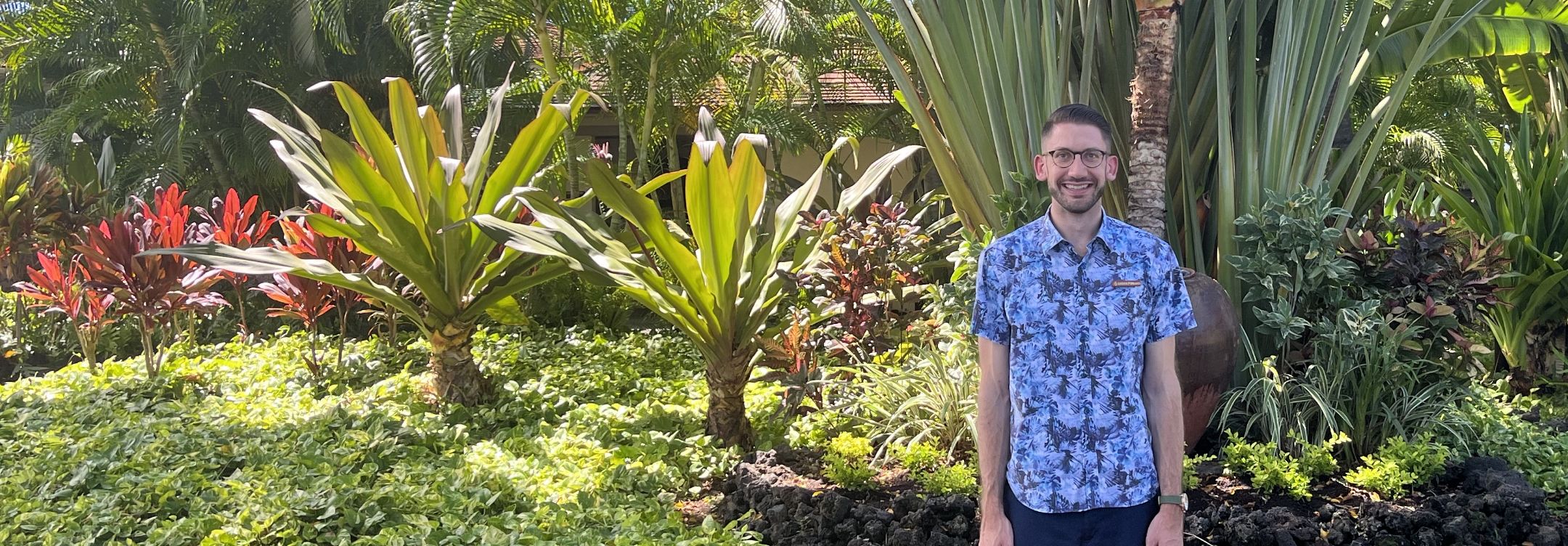 Linden Pohland standing in front of tropical trees