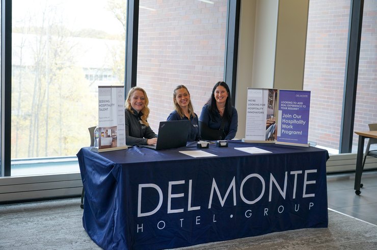 3 workers at a table with the words 'delmonte'