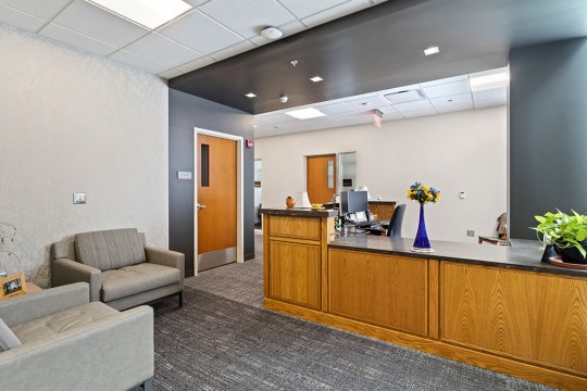 a reception area with soft seating and a large desk.