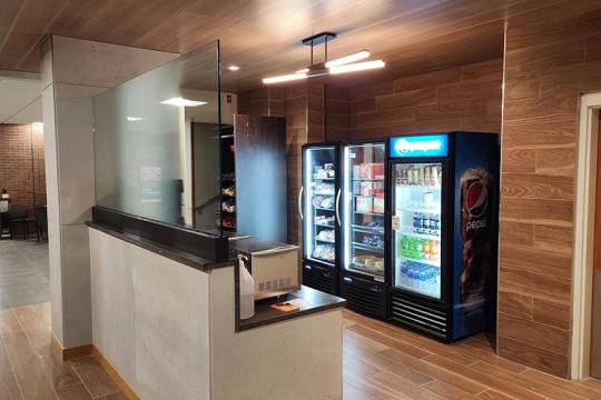 a grab and go market with a vending machine, pantry, glass doored fridge, and a microwave.