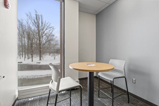 a small meeting room with a table and two chairs.