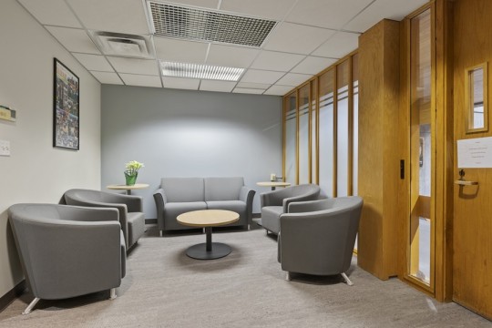 a small waiting room with soft seating and a small round coffee table.