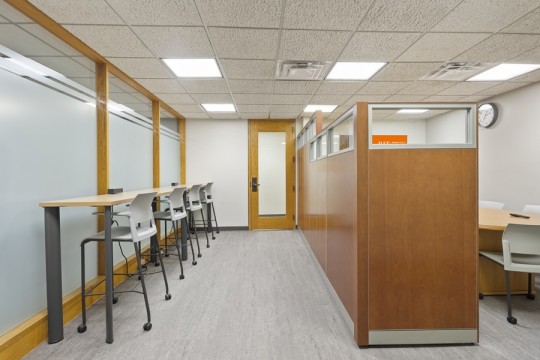 a common area with high top table and chairs and a private meeting space.