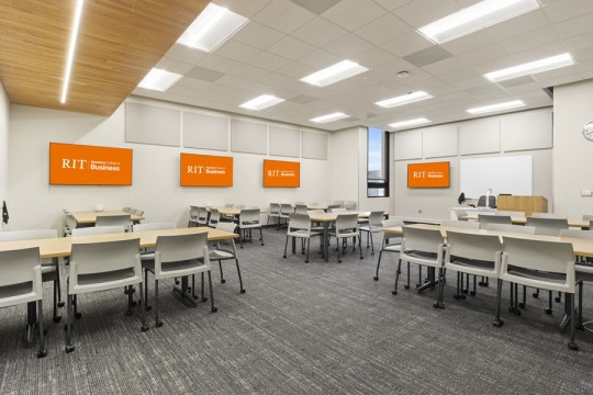 a large classroom space with tables and chairs on wheels.