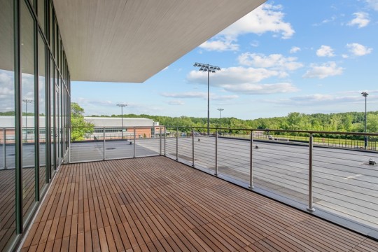 a roof terrace with wooden slat floor and a metal railing.