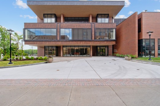 an outdoor plaza space in front of a large brick and glass building.