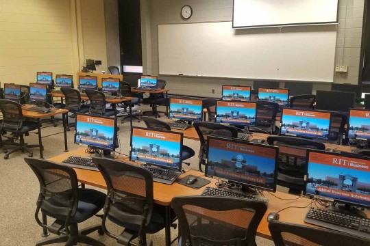 RIT screen savers on in a computer lab with a large whiteboard in the front of the room
