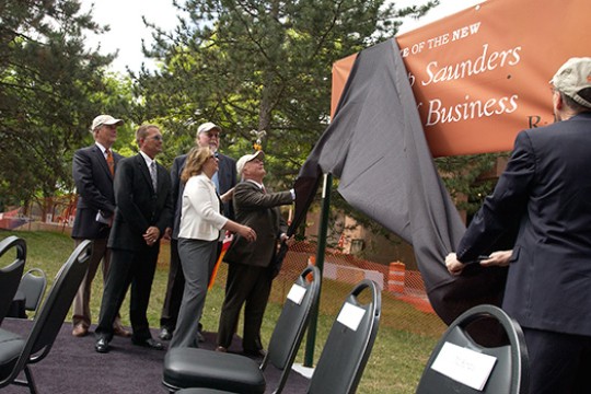 People unveiling "Saunders college of Business" sign at event