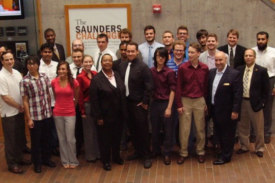 People gathered in front of "The Saunders Challenge sign"