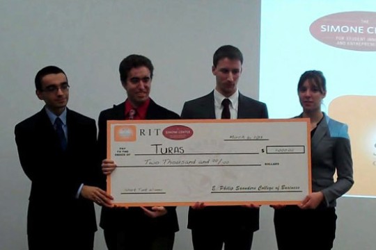 People posing with large check