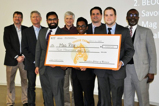 Students, faculty and staff hold giant check.