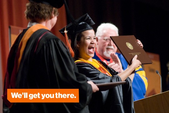 A Saunders graduate student proudly presents her diploma at graduation. 