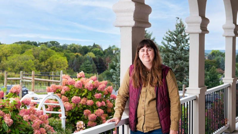 Tara Sarkin standing on balcony in front of flowers at Casa Larga Winery