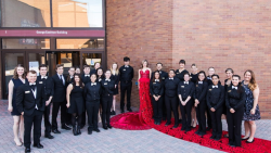 Group standing around a woman in a red dress