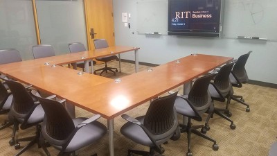 Conference Room with U shaped table surrounded by chairs.
