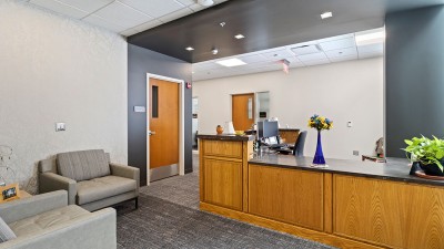 a reception area with soft seating and a large desk.