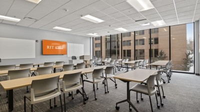 a large meeting room with long tables and chairs, and floor to ceiling, wall to wall windows.