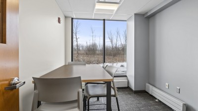a small meeting room with a table and four chairs.