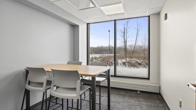 a room with a large window, and a table with four seats.