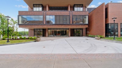 an outdoor plaza space in front of a large brick and glass building.