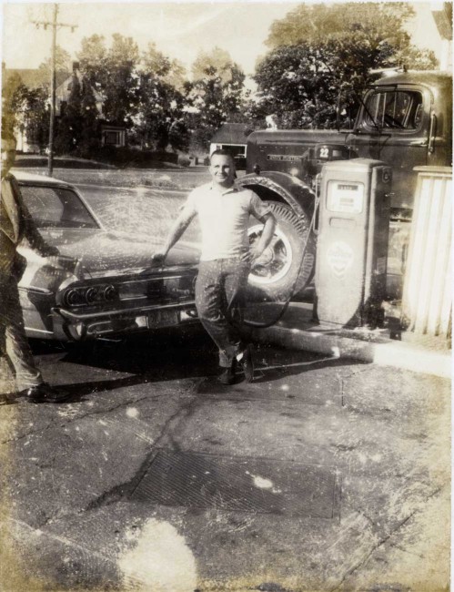 Mr. Saunders posing with a car at a service station