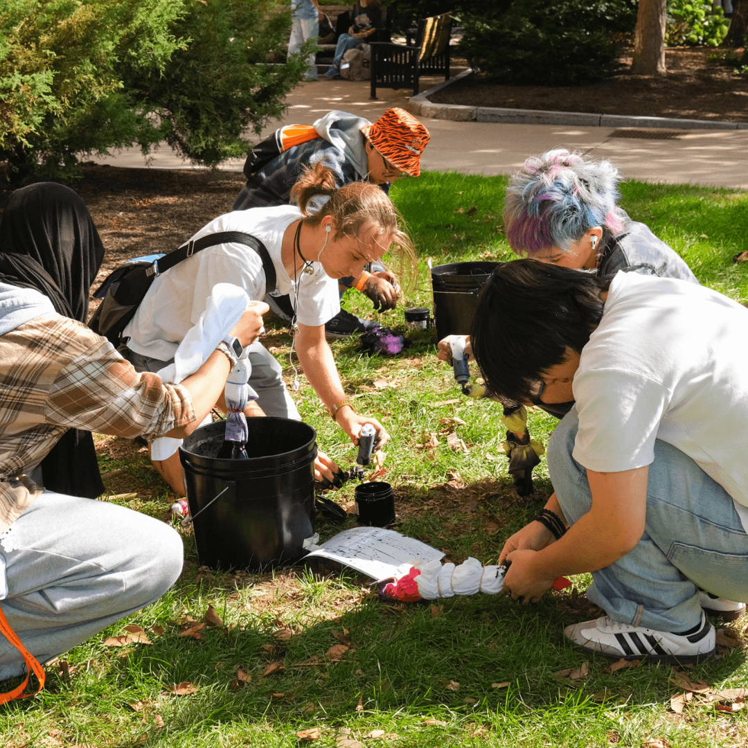 Students tie-dye t-shirts outside on a sunny day at a WGSRC event 