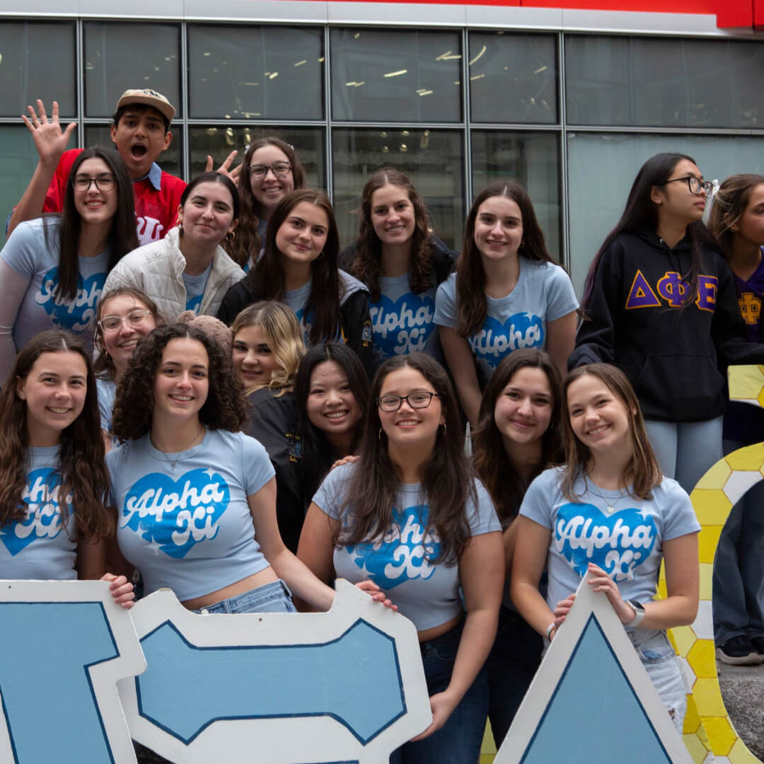 A group of RIT students posing for a photo for their sorority - College Panhellenic Council with Greek letters