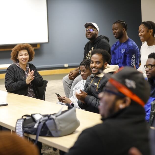 Several students gathered around a couple of tables during a meeting.