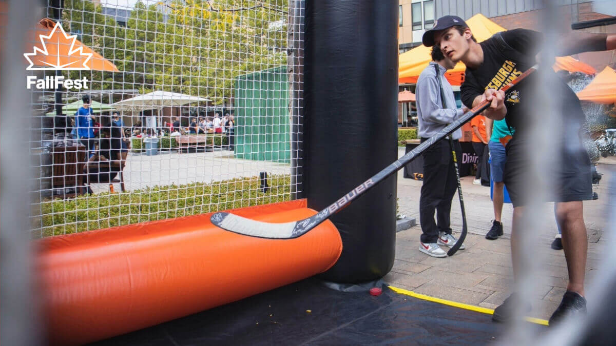 Student shooting a hockey puck during FallFest 