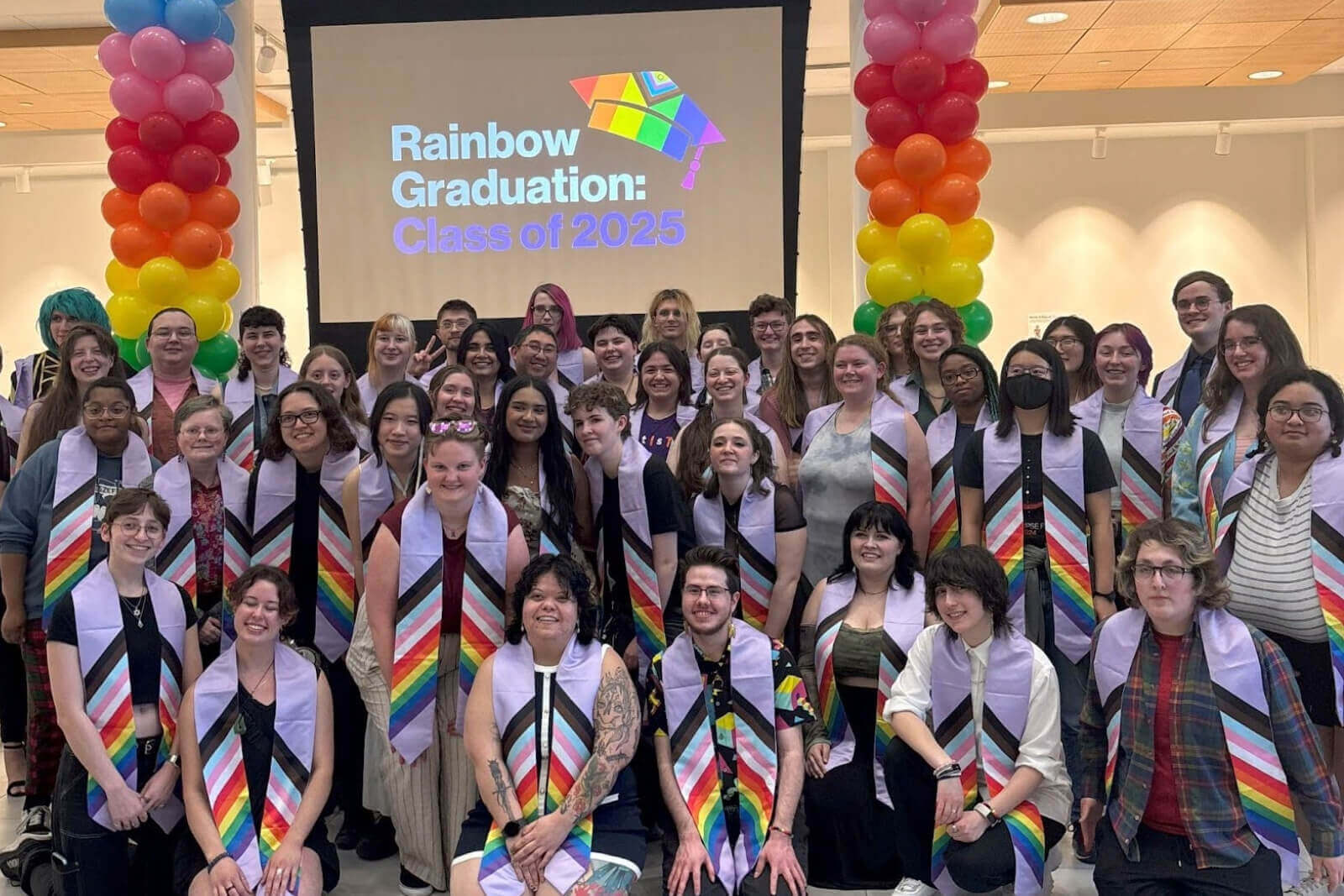 A group of graduates smiling for a photo during Rainbow Graduation 2025