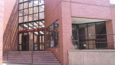 the exterior of a brick building, with steps leading to the entrance.