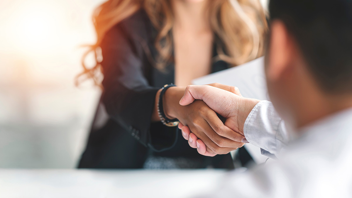 Close-up of a handshake between two people in professional attire.