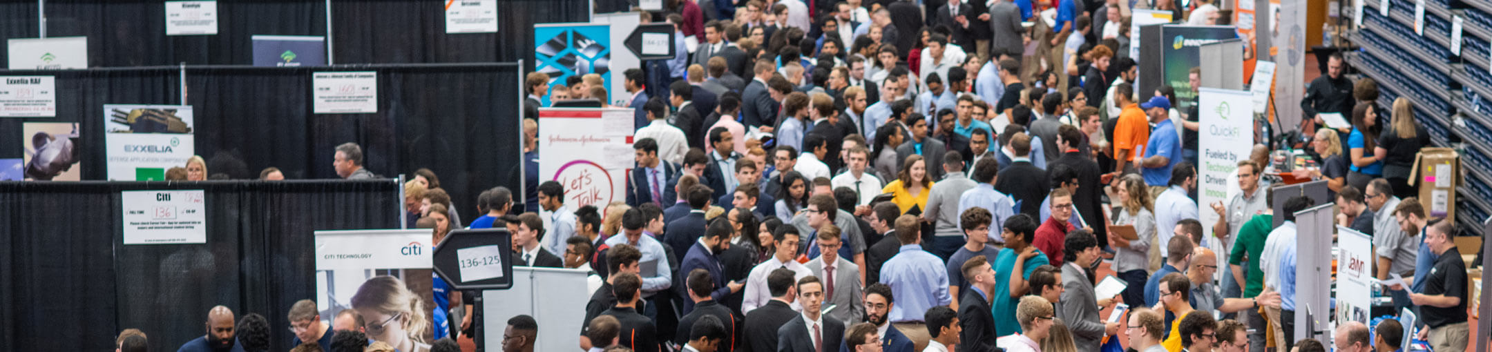 An aerial view of a multitude of students meeting with company representatives at the career fair.