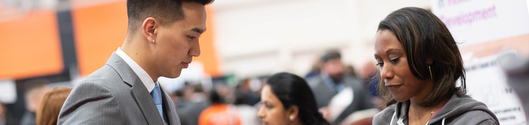 An RIT student talking to a representative from a company at a career fair.