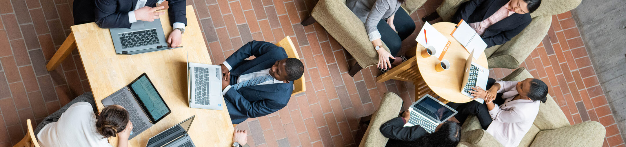 Small groups of people around tables conducting mock interviews.