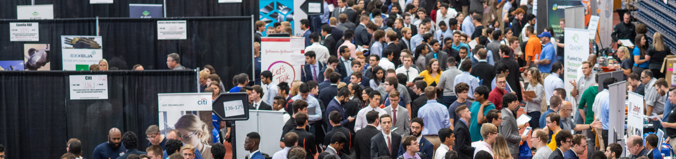 An aerial view of RIT students at the booths of various companies during a career fair.
