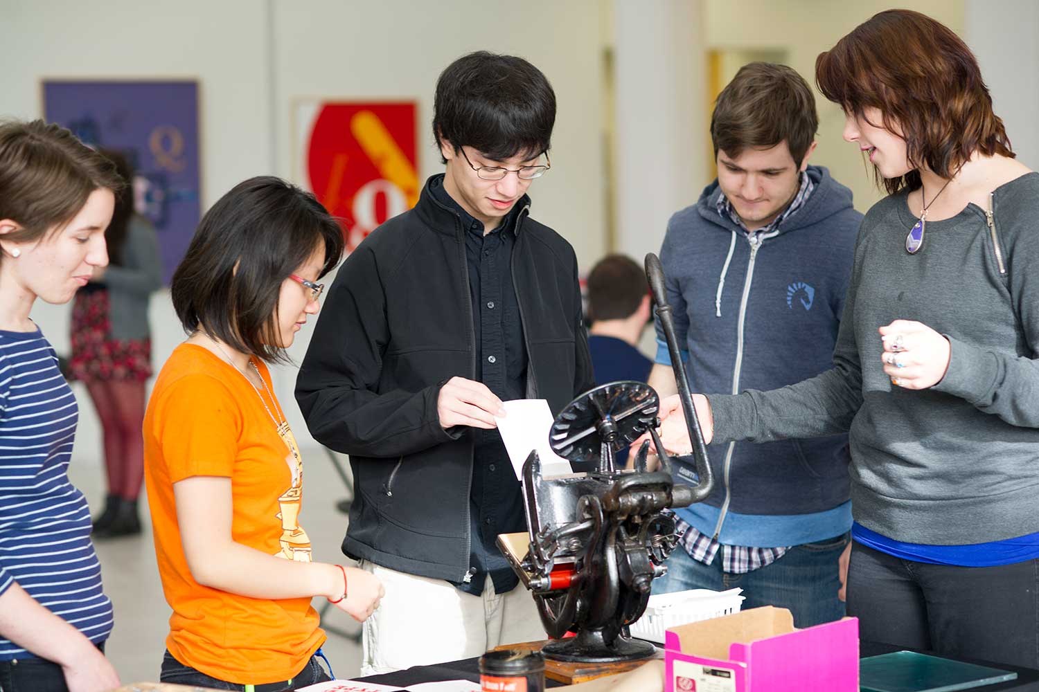 Students interacting with a printing exhibit