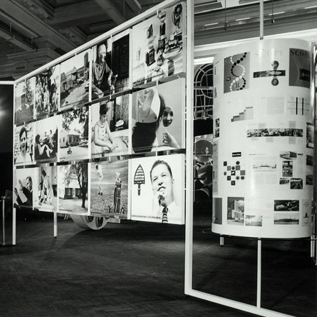 Photograph.  Spectators viewing “working conditions in Kalamazoo” at Kalamazoo...and how it grew! exhibit, shown throughout England, 1958.  Photographer: Gordon McLeish and Associates.