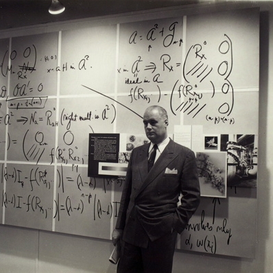 Photograph. Will Burtin at Integration exhibit leaning against the wall, shown at A-D Gallery, New York City, 1948. Designed by Burtin. Photograph by Arnold Newman.