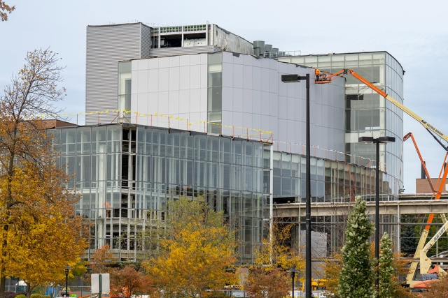 exterior of a multi-story glass building under construction.