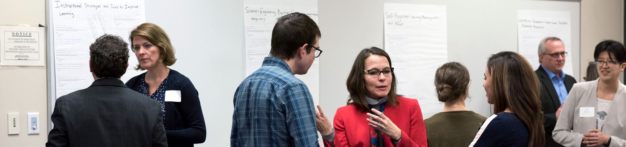 A group of faculty discussing various topics in a classroom.