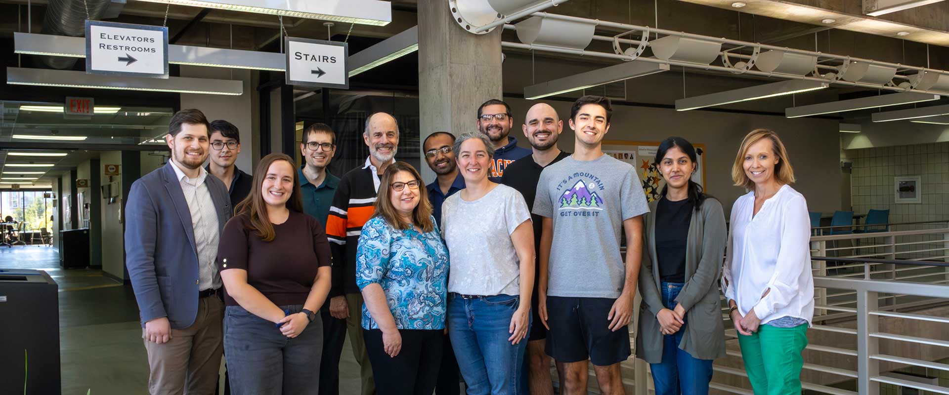 a group of 13 faculty members posing for a photo.