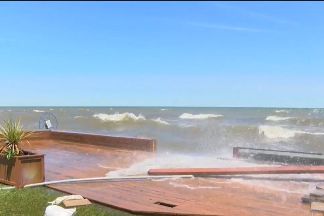 waves crashing over a breakwall.