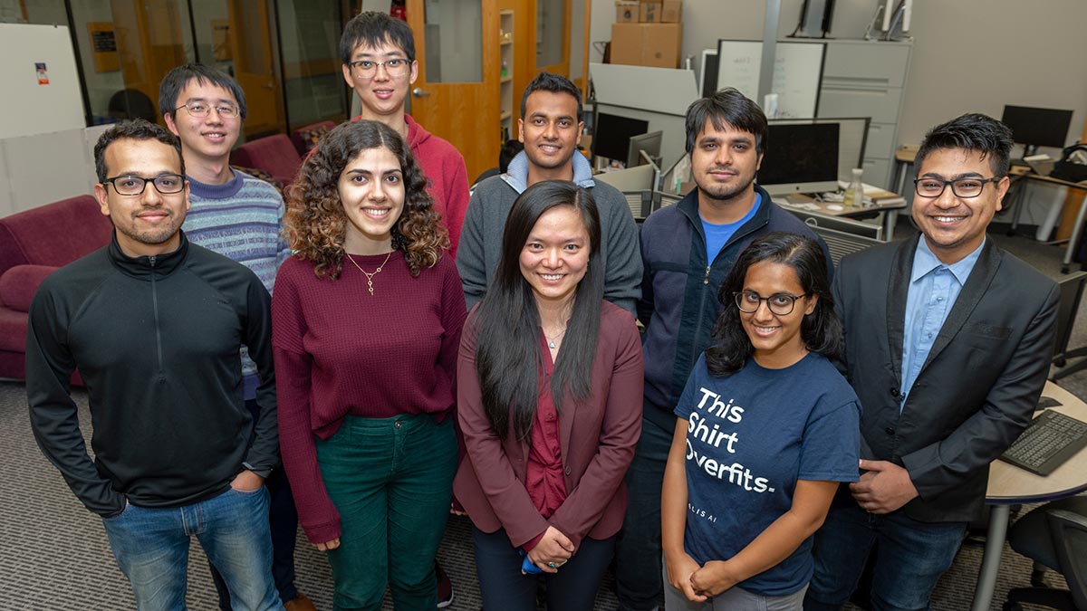 group of nine people poses for a photo.